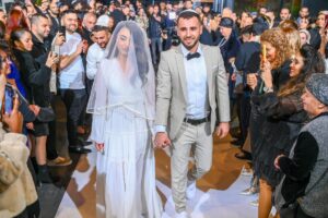 זוג מתנשק בטבע באור יום רך בסגנון צילום חתונות אותנטי